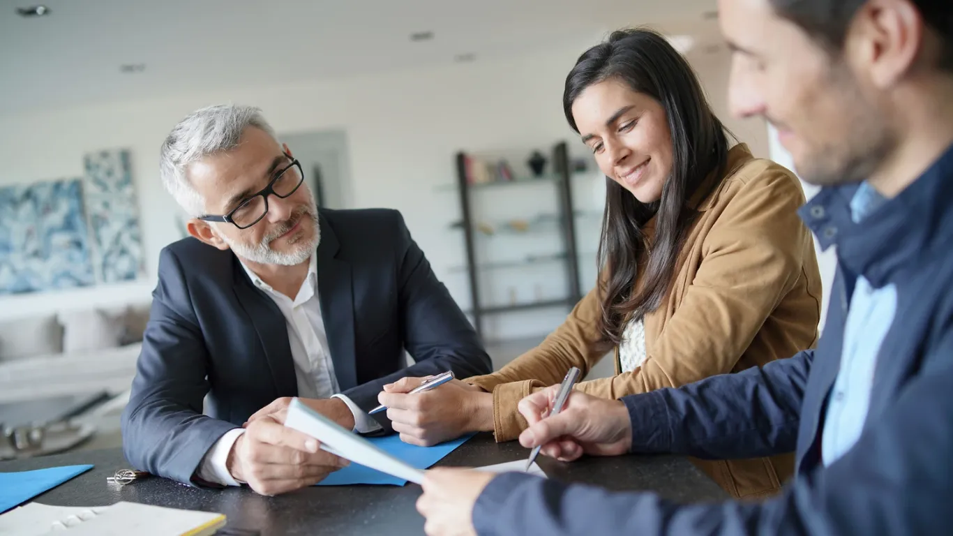 Asesor y clientes firmando un contrato