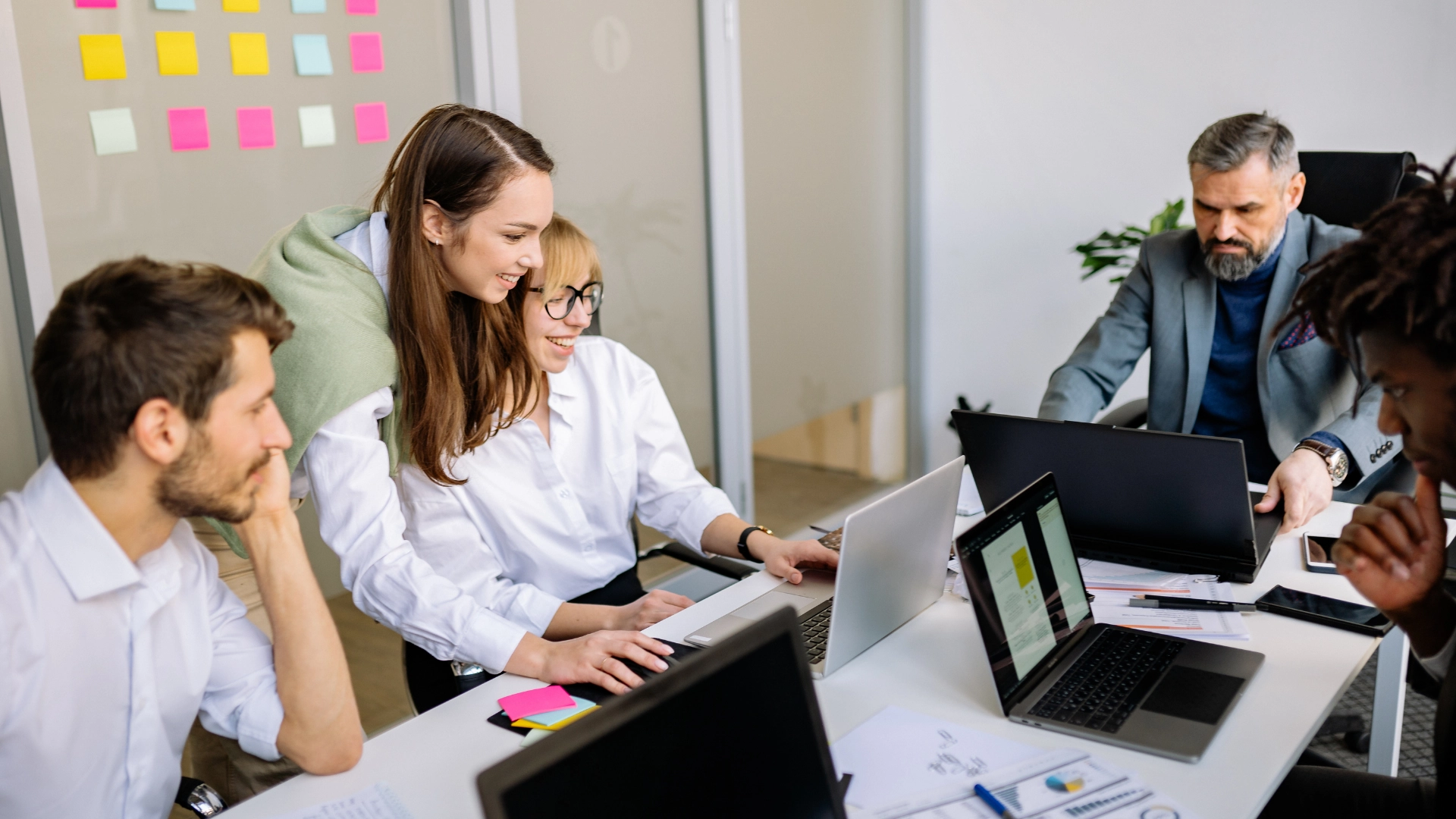 Equipo de trabajo de una empresa reunido alrededor de una laptop
