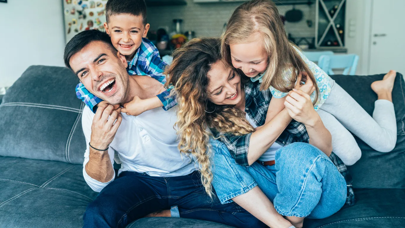 Familia jugando en el sofá de su casa