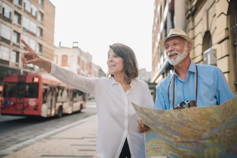 Pareja de adultos mayores orientándose con un mapa en la calle